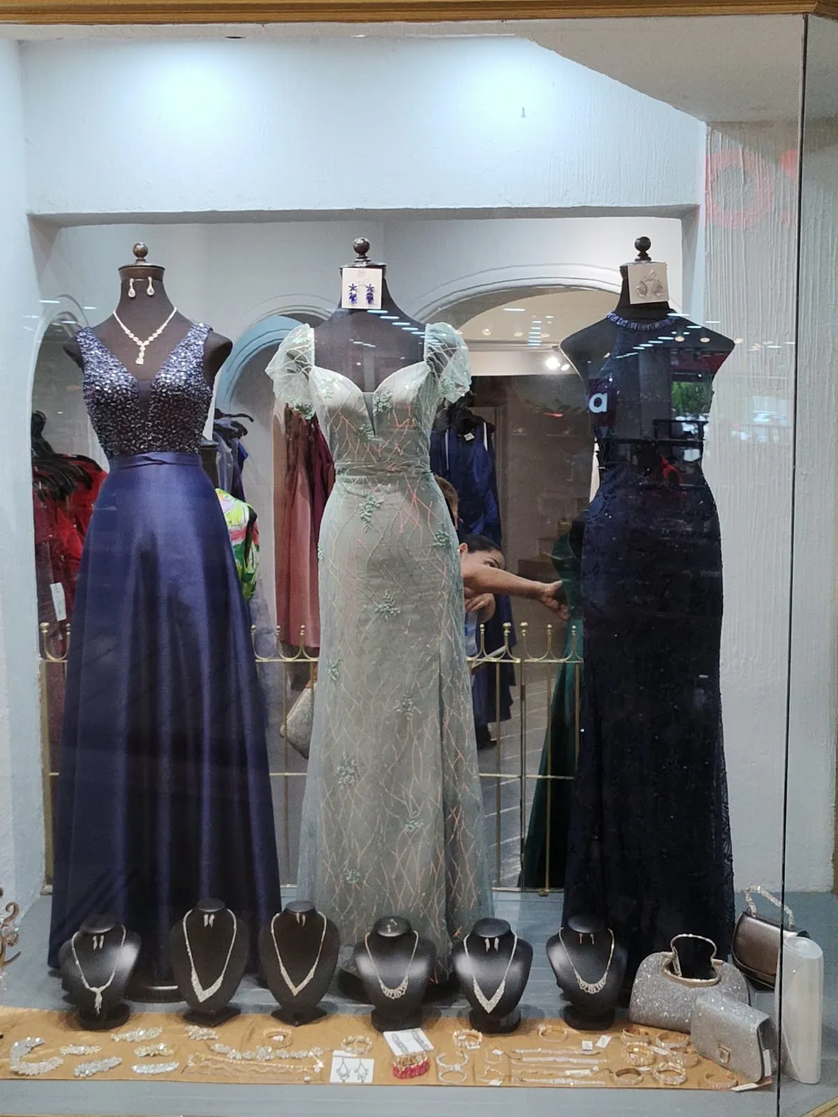 Aparador con vestidos azul marino, marfil bordado y negro de encaje